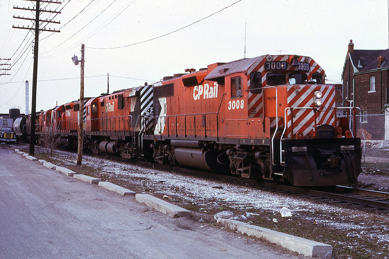 When CN Dundas station was reduced to Agent-only status in February 1973, I didn't have too many choices as to exercising my seniority. So I claimed 2nd trick at CN West Toronto with Tues & Wed off. Turns out I actually enjoyed that place. CP's Mactier Sub was on the opposite side of the building from CN's Weston Sub and a little warning of an impending move would be to have the gates come down for old Weston Road. Here we see timetable train 82 with two year old GP38AC 3008 in it's original paint leading a C-424, an SD40, an RS-10 and another C-424 as it passes the CN parking lot and gets ready to make the turn onto the North Toronto Sub. Just another quiet Saturday afternoon and evening in the meat packing district.