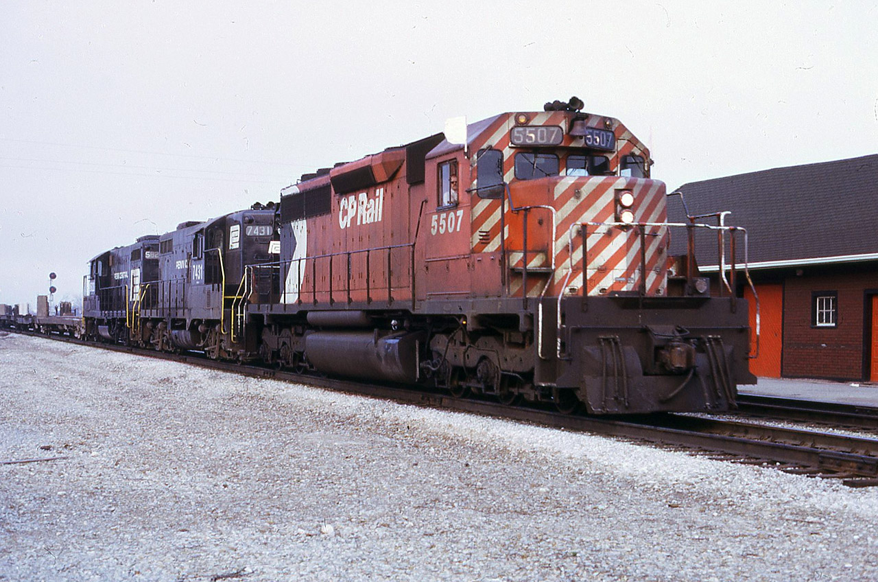 CP 5507 leads Penn Central GP9 + GP7 7431-5820 through Burlington on the daily STARLIGHT  (Agincourt/Aberdeen). Building to the right is the CP Express office situated immediately east of CN Burlington station. This train brought all the local traffic for TH&B to distribute to local industry, including the empty piggyback flatcars for either Chatham Street or Forest Ave. The two PC geeps were laying over in Agincourt Yard after arriving earlier in the day from Buffalo.