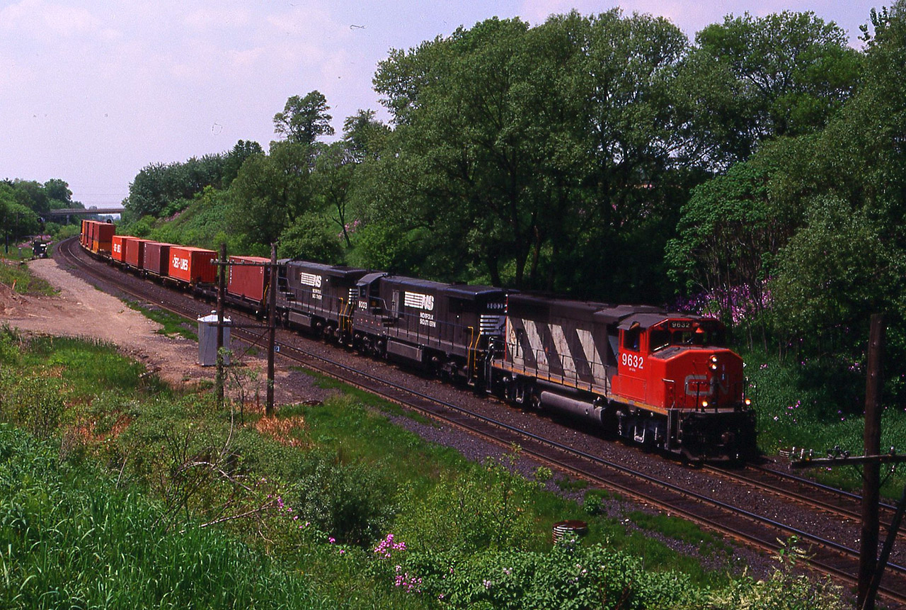 NS power was abundant on both railways in 1997. CN leased some NS GE's while NS power was being mixed on their own trains (327/328) with CP engines. Here's intermodal train 144 with NS 8003-8004 handling another mile long consist as they tip toe across the underground river at Inksetter Road. The spring flowers are almost finished.