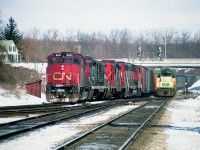 GO 507 is temporarily on CN passenger service as train #73 races westward alongside a freight about to head up the Dundas sub. The passenger is pulling 9 coaches; the freight, behind CN 9631, 4584, 4536 and 9647 according to my notes are 87 cars and caboose 79568 in tow. Nobody out on the walkbridge this day; and interesting to note how wide open the "railfan house" is back then. We used to comment on being the owner of that house if it ever came up for sale.
