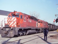 A westbound with 1 green flag passes through Chatham on the CP Windsor Sub on Feb 23/84 with 5545-4560 doing the honours. I had positioned myself at this particular crossing (the name of which I forget) with the sole intention of having a train pass by the wigwags. Unfortunately one of the locals came walking up just as the train arrived. I believe thats a Marathon Realty sign behind the crossing signal pole.