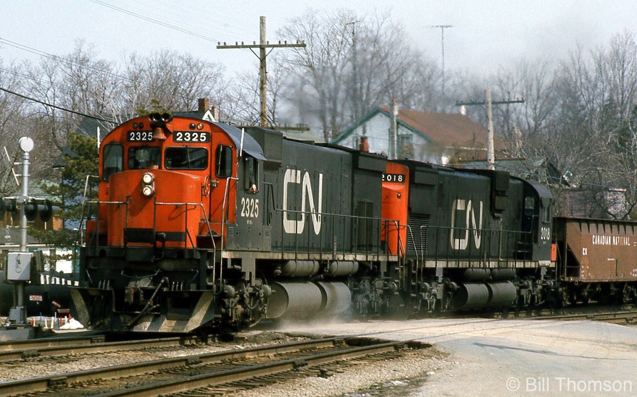 CN M636 2325 and C630M 2018 head west on the Dundas Sub through Paris Junction in April 1975. CN purchased many 4- and 6-motor mainline freight units from both GMD and MLW in the 60's and 70's, and the big M's were some of the largest MLW had to offer at the time.