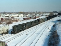 Here is an interesting view.  From up on the old Central Av overpass we see CR 5793, 5739 and 5795 bringing a transfer from Buffalo into Canada. Note all the truck frames. Note the fact this is 4 years after the formation of Conrail and all three GPs are still in either NYC or PC black. And the old connector is still in place in front of the passenger station........I used to refer to this as the 'NYC' line because when I first got to exploring down there, on the west side of the overpass was a "NYC Yard" sign, one of those old wooden namesigns we used to see so many of; and it was firmly fixed in the brush. So it couldn't go home with me. The 'B-1' Bridgeburg station is still in place at the International Bridge, as well the old CN Crew Hostel can be seen on the extreme right. And the track off to the right where Boeing cars were left for the aviation industry is still in. The CN station that was there is 6 years removed, otherwise I could have had three stations in one frame. Bridgeburg, which merged with Fort Erie still looks rather clean. Now, that street off on the left side is run down and decrepit. All these years this particular roll used in late 1980 was the only time I selected 'Blacks' film, strangely enough. Nothing against it; it turned out not too bad.