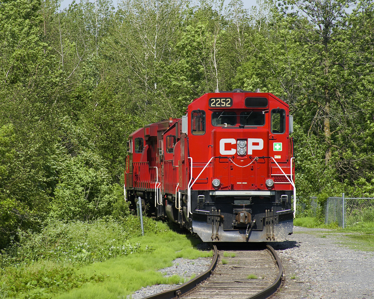 A black eye? It almost looks as if CP 2252 has a black eye, with one of its numberboards missing or blanked out. It is parked on a wye track at Delson that used to connect to the CN Massena Spur but is now a stub track, as the power rests on a scorching Sunday afternoon.