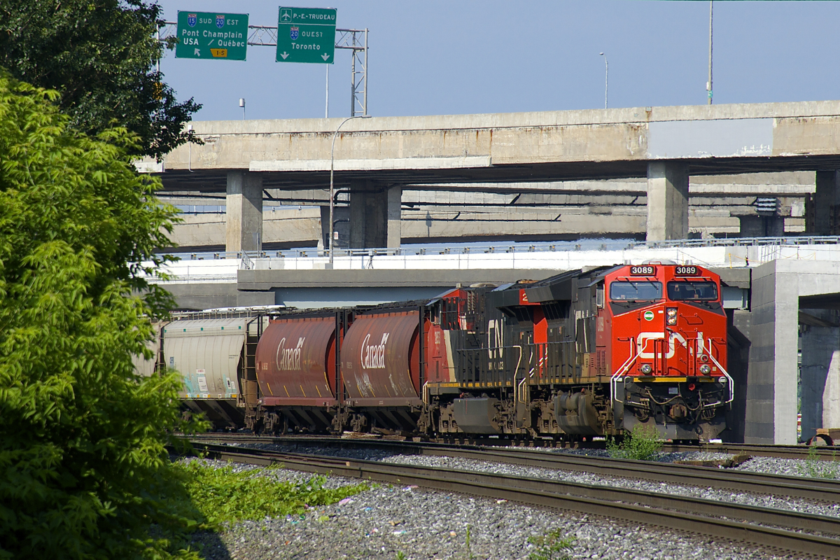 CN 878 with  & CN 2853 for power is parked on CN's Montreal Sub in the morning, as the Port of Montreal would not be ready to take it for quite some time. Up above is the Turcot interchange, which will soon be replaced by a newer set of ramps and exits. CN 878 originated in Canora, SK. Grain trains east of Thunder Bay are quite rare in the summer, but a number of CN 878's have run to Montreal during the past couple of weeks.