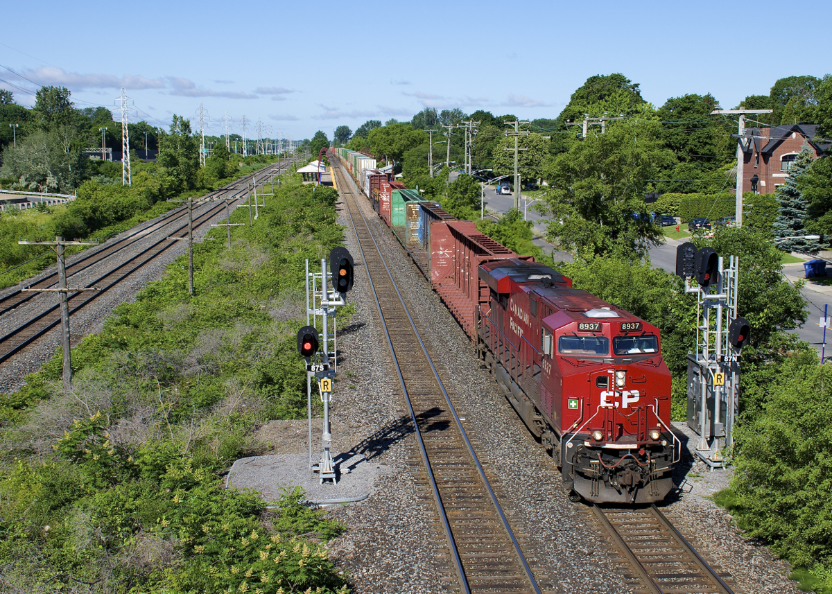 What a difference a year makes. A bit over a year ago I shot CP 118 splitting this set of signals on CP's Vaudreuil Sub in Pointe-Claire, and the tracks were surrounded by a wall of trees. CP (and/or CN, whose Kingston Sub is just at left) did a lot of brush clearing this past spring, and it's a very different scene as a 452-axle CP 112 passes with CP 8937 up front and CP 9352 mid-train this morning.