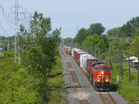After setting off part of its train at Coteau, CN X372 has only 70 cars as it approaches the St-Jean overpass in Pointe-Claire with CN 3048 & CN 2905 for power.