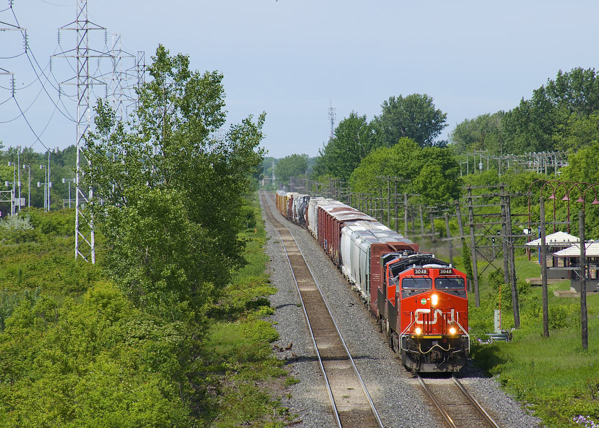 After setting off part of its train at Coteau, CN X372 has only 70 cars as it approaches the St-Jean overpass in Pointe-Claire with CN 3048 & CN 2905 for power.