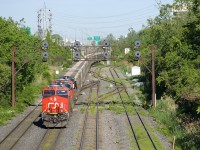 It's a busy morning on CN's Montreal Sub as CN B730 passes under the signal gantry at Ballantyne, just east of the eastern entrance to Taschereau Yard. CN 149 is lined on the south track at far left, CN 305 is just behind it and CN 529 has just entered Taschereau Yard. Loaded potash train has the usual complement of 4 AC units (CN 2841 & CN 2850 up front and DPU's CN 2958 & CN 2966) and 205 cars.
