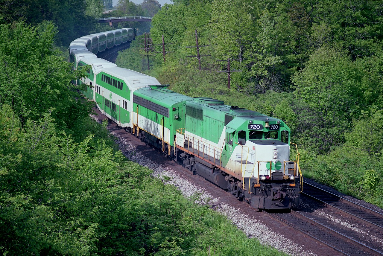 The foliage is getting up already, it is almost the end of May as I am looking out from the Wolf Island bridge (old Hwy2; now Plains Rd) grabbing a shot of a Hamilton-bound GO. Interesting thing about this train, and something largely forgotten by the fans, is the presence of an APU (Auxiliary Power Unit) behind the GO 720. There were only 3 of these on the GO roster, 800-802. This unit, 802, as well as the other two was a former Northern Pacific F7B. These helped with head end power (HEP) as the twelve car train needed light and heat and all this was a excess burden on a GP40 leader.  Once GO acquired their fleet of F59PHs, the APUs were no longer needed. One was sold and two were scrapped in 1995.
