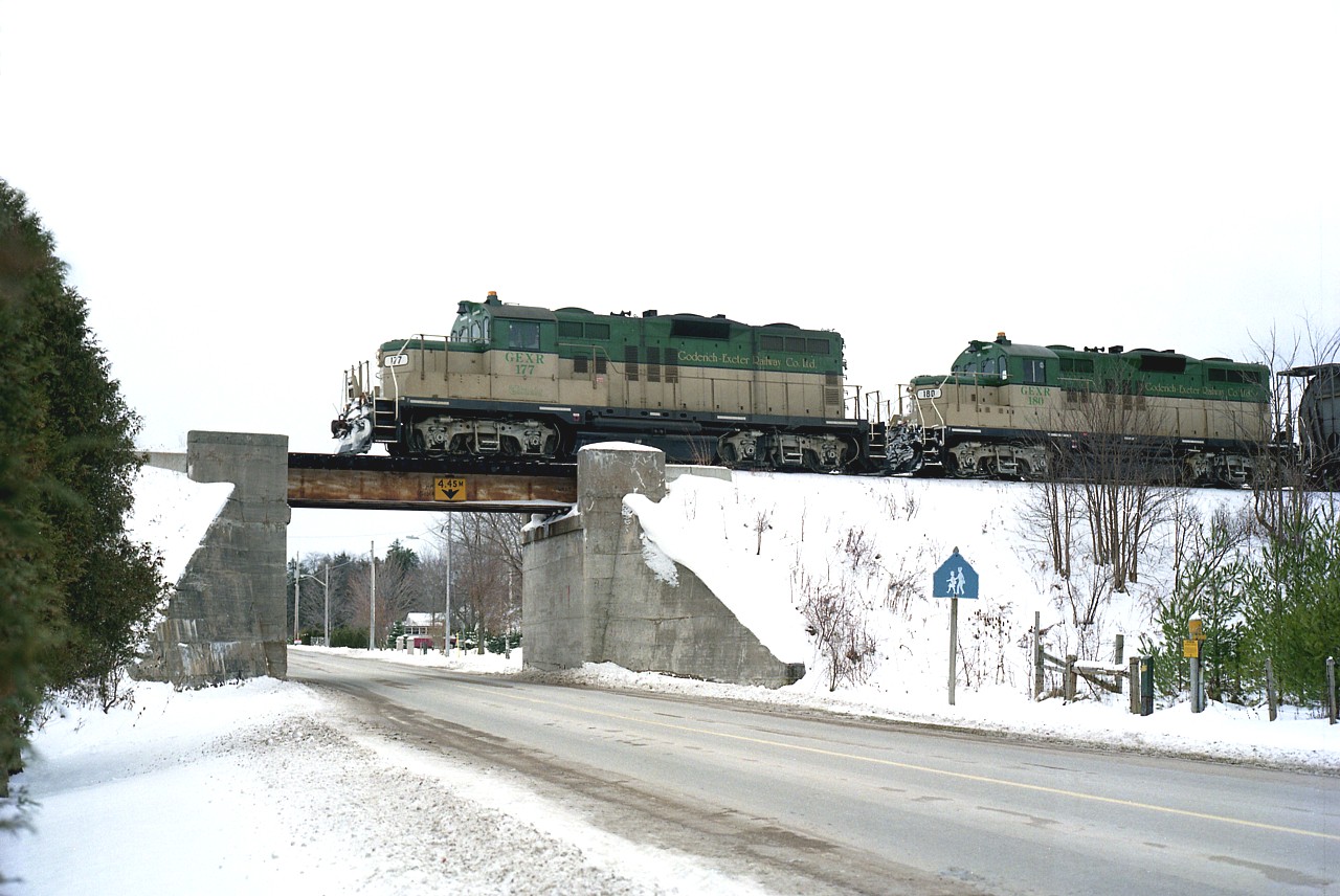 This is the very first year of the Goderich-Exeter Railroad operations, having started up 8 months earlier in April. Two of the company's 4 GP9s are seen here rolling over the first of two overpasses in Holmesville with a train for Stratford. Checking a couple of other images I took, I see that GEXR 177 and 180 have about 25 salt cars and a couple of flatcars of Champion Roadgraders, another long gone business in this suffering province. (Volvo bought the Goderich plant in 1997 and they too bailed out in 2008.) Also in 2008, the #177 was scrapped, and the #180 was moved to Michigan Southern.