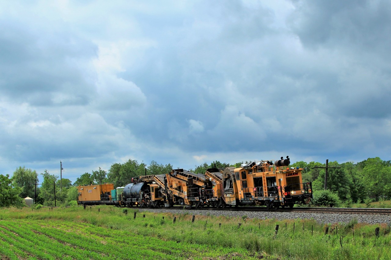 The Loram shoulder ballast cleaner, LMIX 424, rounds the bend after crossing Victoria Road on its way to Welland.