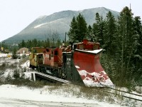 Prior to the last run on the isolated Kaslo Subdivision, only accessed by car barge on Slocan Lake, the crew rounds up M of W equipment stored at Nakusp. The train crosses Kuskanook River headed to the wye where snow plow will be put in trailing position for trip to Rosebery 