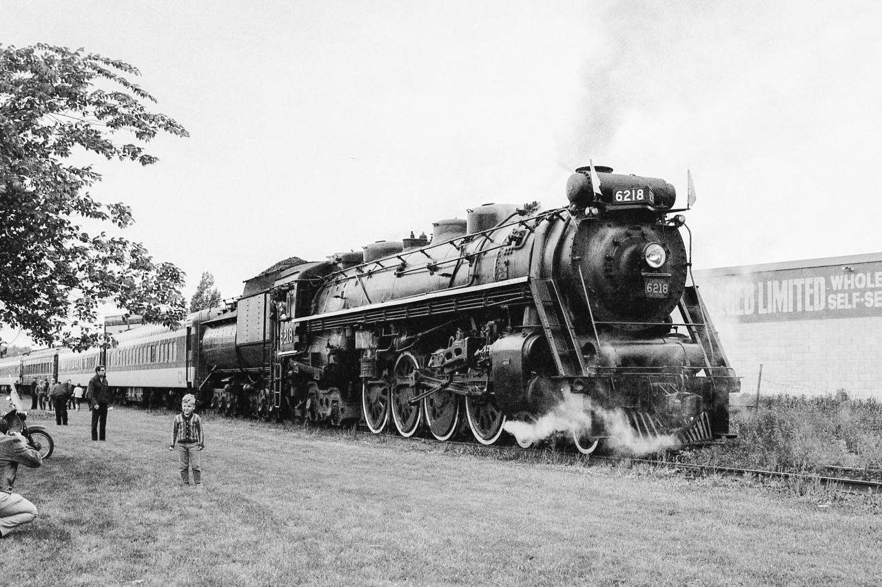 I believe it was the first Saturday in June 1970 when fellow railfan John Woodworth and I crossed into Sarnia only a few minutes prior to CN 6218's leaving on an eastbound excursion. The early morning was cloudy with a slight trace of fog. We found her by an unknown park where I believe the boarding was taking place
Here is CN 6218 just a few minutes before its departure. At the far left is a photographer taking a photo of the child with 6218 in the background.