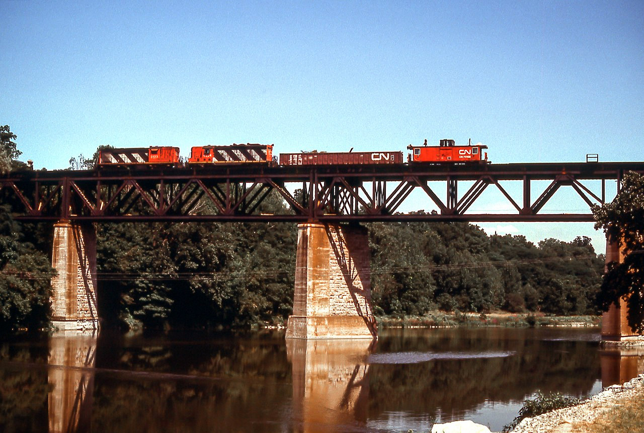 CN 3123 heads west over the Grand River in Paris, Ontario on August 9, 1985. The photo was taken from a little park on the east side of the river.