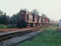 I had been in southern Ontario for a family function and went to Chatham to visit friends there. Being railfans we were out and about and got some slides of this eastbound passenger train leaving Chatham. This image is a "crop and zoom" and hopefully captures the scene. Four MLW's (3127-3108-3112-3121) were in charge moving this train. I am not sure of the train number, but, I'm sure Bruce Mercer would know as he was right beside me taking in this view. 
