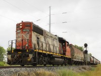 <b> YOU NEVER KNOW HOW QUICKLY THINGS CAN CHANGE! </b> This country scene has changed since the early years when the Michigan Central built it's east to west mainline through Southwestern Ontario. When they came across the old mainline (later) known as C&O Subdivision # 2 that ran north to south, a diamond was formed. So too was a connecting track to exchange traffic. And this location then became known to both railways as Fargo (or Fargo Crossing). 
<br>
<br>
Here a rather dilapidated looking CN 4771 heads back north to Chatham after exchanging grain cars at the Thompson's facility in Blenheim. It passes the CTC signals that have been turned away, no longer in need of service. The former MC (and later CASO) road bed was bought by the local hydro company Entegrus. They erected the rather large hydro pole seen in behind 4771. And that pole marks where t he once mighty MC (later CASO) ran it's mainline. The former C&O Sub. # 2 has also fallen from it's glory days, but barely remains in service thanks in part to CN taking over the "Blenheim Operation" when the CSX wanted to abandon their line.