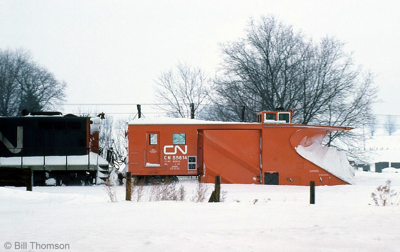 CN snowplow 55614 heads out north from Palmerston ON, clearing the line in February 1977. Plow 55614 was unique being the only "V" plow built by Jordan. It was later transferred to the Maritimes and painted black.

Note: Geotagged location not exact.