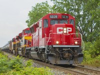 Having received another tip, today's 650 - the ethanol train - was supposed to be a catch with a SD-30 ECO and a tcouple of 'Southern Belles' thanks to the Kansas City Southern. BUt weather wise, Today turned out to be one of those days - torrential downpours to start, then it cleared and the sun was out, quite warm, then it clouded over again. While being at work, I ducked out on my breaks and lunch standing in the humidity just hoping to see this train in Chatham. No luck. 
<br>
<br>
Having to go to Jeannette's Creek, I had just turned onto the Coutts Line from Merlin Road and rounded a curve, cleared some trees...my luck changed. There was 650!!! Sure enough, panic set in. I stopped and backtracked a little to Merlin Road. There was a private driveway, so I walked up and lined up my shot. Here, CP 5039 with KCS 4193 & 4768 leads a long line of tankers blowing it's horn for the crossing. 
<br>
<br>
Looking back, would you have done what I did to get a fairly good shot? Or would you have just stopped, and gone for a quick side shot hoping to capture all the power leading this train? Let me know your thoughts... :)