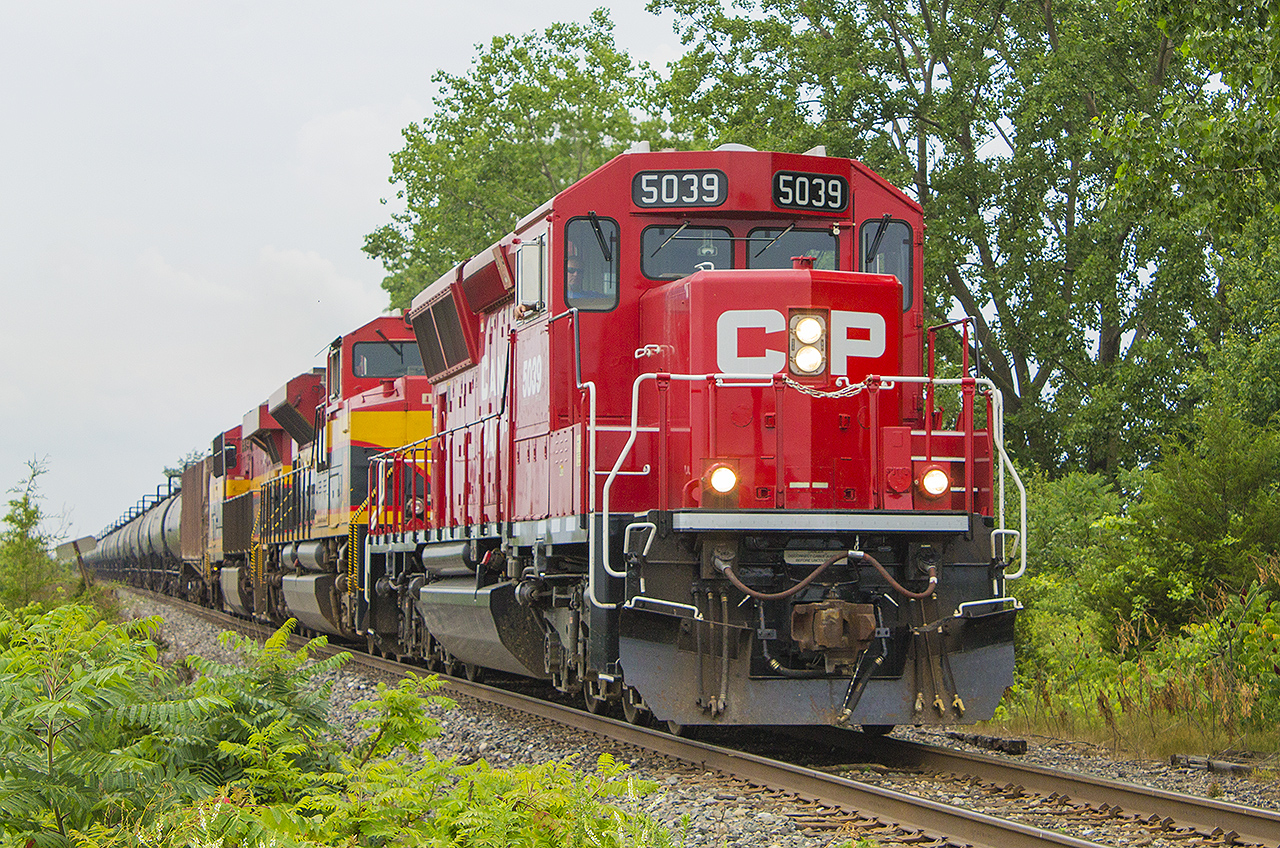 Having received another tip, today's 650 - the ethanol train - was supposed to be a catch with a SD-30 ECO and a tcouple of 'Southern Belles' thanks to the Kansas City Southern. BUt weather wise, Today turned out to be one of those days - torrential downpours to start, then it cleared and the sun was out, quite warm, then it clouded over again. While being at work, I ducked out on my breaks and lunch standing in the humidity just hoping to see this train in Chatham. No luck. 


Having to go to Jeannette's Creek, I had just turned onto the Coutts Line from Merlin Road and rounded a curve, cleared some trees...my luck changed. There was 650!!! Sure enough, panic set in. I stopped and backtracked a little to Merlin Road. There was a private driveway, so I walked up and lined up my shot. Here, CP 5039 with KCS 4193 & 4768 leads a long line of tankers blowing it's horn for the crossing. 


Looking back, would you have done what I did to get a fairly good shot? Or would you have just stopped, and gone for a quick side shot hoping to capture all the power leading this train? Let me know your thoughts... :)