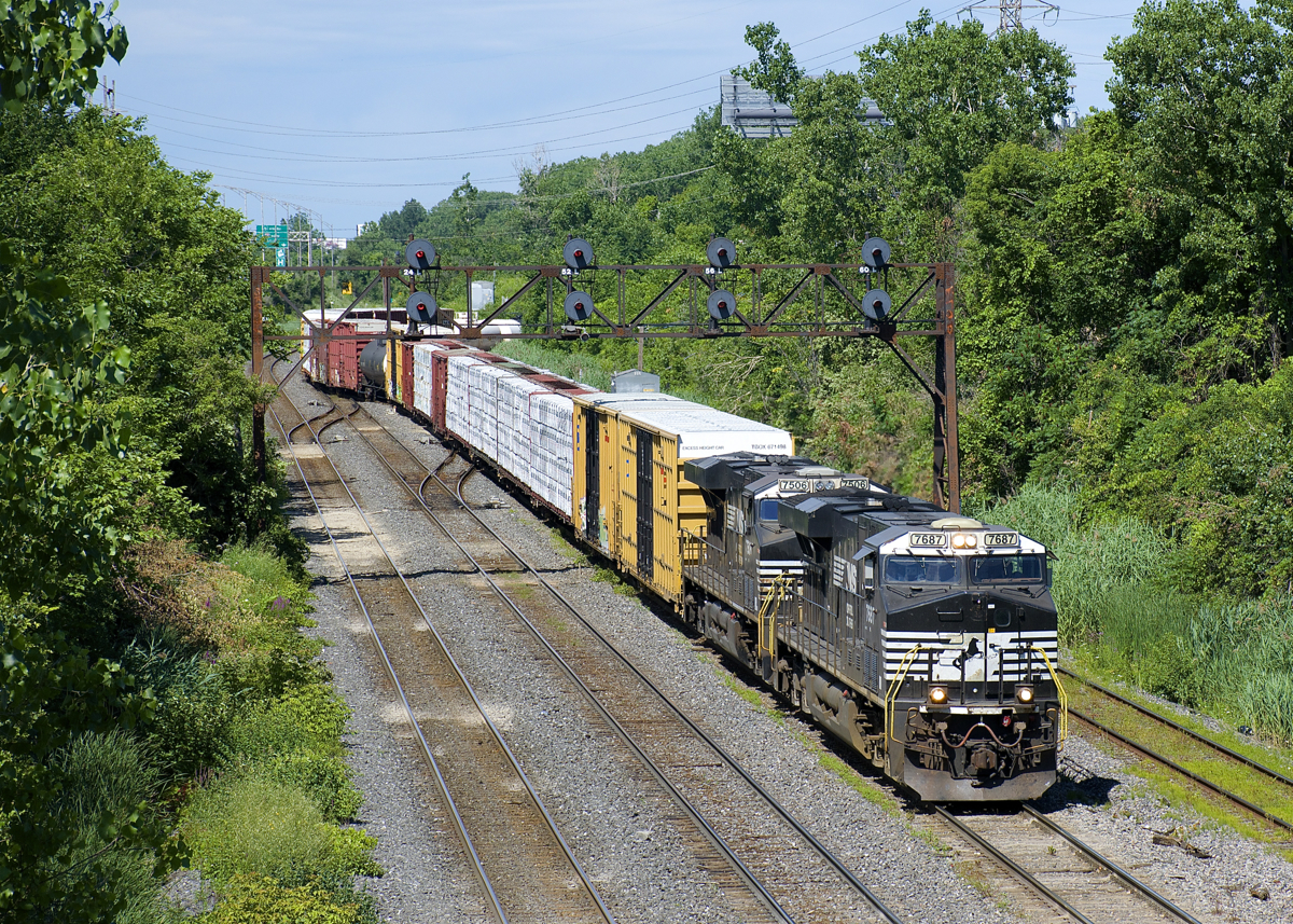 CN 528 is exiting Taschereau Yard with 52 cars and a pair of ES44DC's as it crosses from the north track to the freight track on CN's Montreal Sub. The CN crew will bring the train to Rouses Point and bring CN 529 back. Later a CP crew will bring it south as CP 930, eventually it will get onto NS rails where it's IDed as NS 30T.
