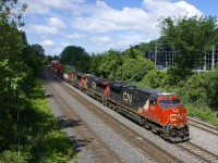 The head end power on CN 120 (CN 2887, CN 2235 & IC 2700) is barely staying ahead of some clouds as CN 120 heads east on the Montreal Sub. The DPU on this long train bound for Halifax was CN 3049.