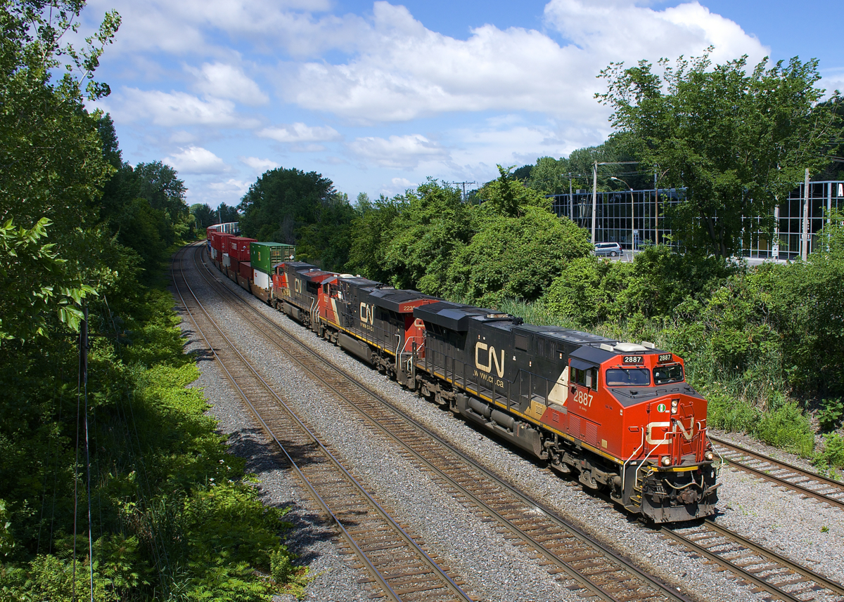 The head end power on CN 120 (CN 2887, CN 2235 & IC 2700) is barely staying ahead of some clouds as CN 120 heads east on the Montreal Sub. The DPU on this long train bound for Halifax was CN 3049.