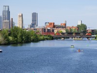 CN 2873 and CN 3039 lead CN 324 over Lachine Canal on a warm afternoon in Montreal, with the downtown skyline in the background and a number of boaters out on the canal.