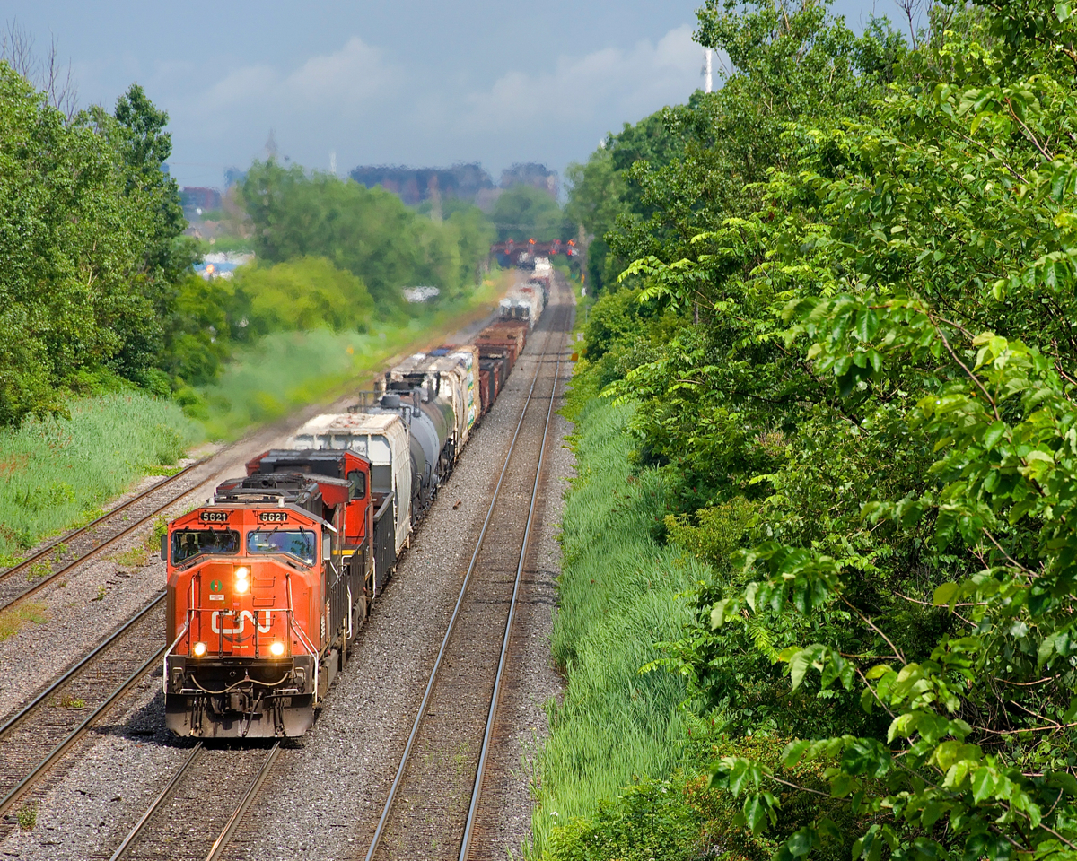 CN X321 has CN 5621 & CN 2646 for power and overflow traffic from Southwark Yard in St-Lambert as it slowly heads west through Lachine not too long after the sun came out after a quick downpour.