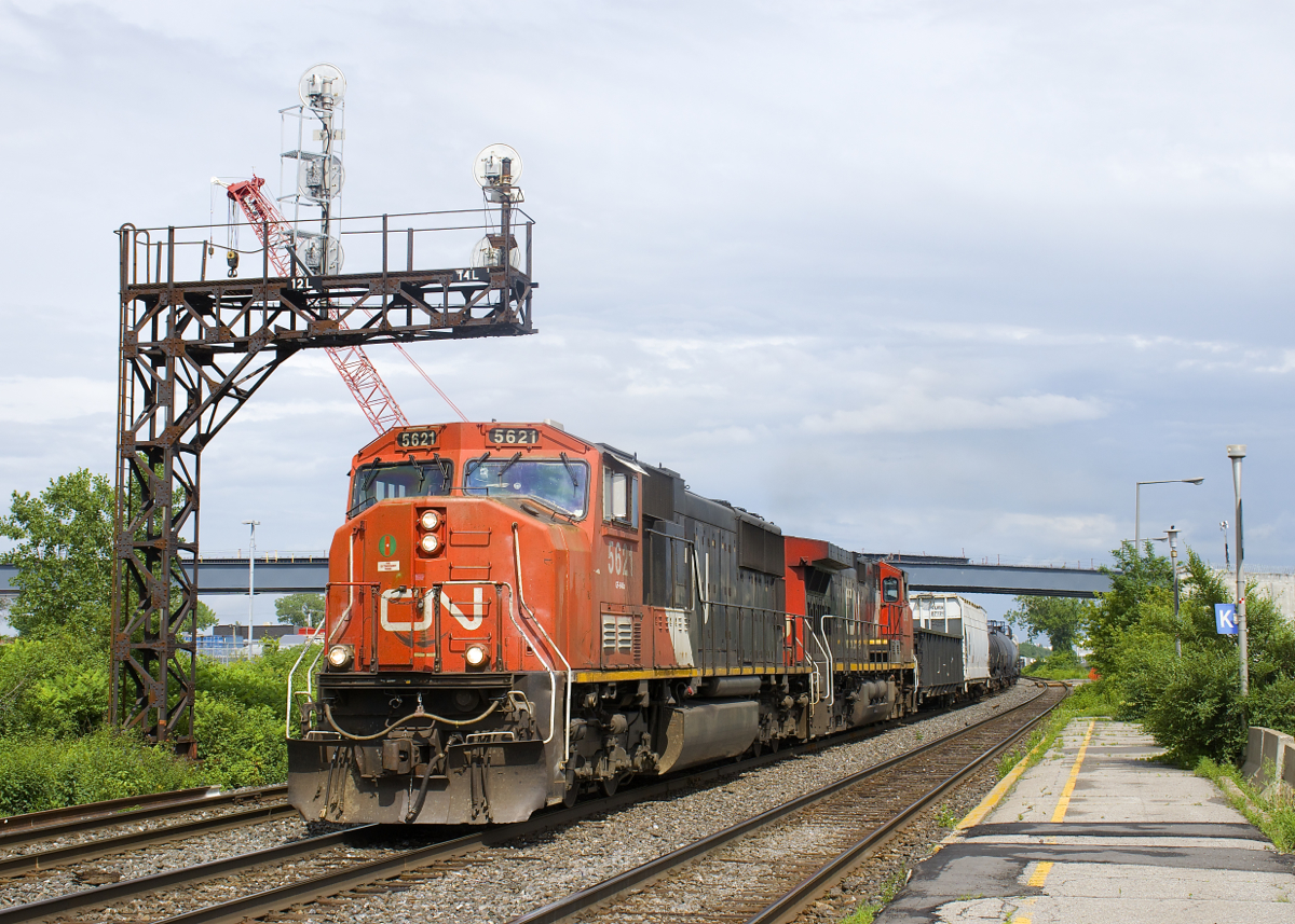 CN X321 has CN 5621 & CN 2646 for power and overflow traffic from Southwark Yard in St-Lambert as it approaches the VIA Rail Dorval Station not too long after the sun came out after a quick downpour. In the background is construction for what will be a new overpass over the CN and CP tracks here.