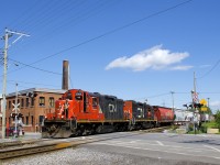 CN 7083 & CN 7054 are heading west on the north track of the Montreal Sub as they cross St-Ambroise Street. Soon they will back up on the East Side Canal Bank Spur and drop off eight cars at the Robin Hood Flour Mill.