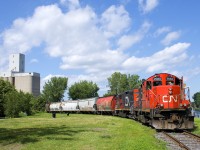 CN 7083 & CN 7054 shove eight cars grain cars into the Robin Hood Flour Mill on CN's East Side Canal Bank Spur. As its name implies it follows the bank of a canal, namely the Lachine Canal, which is visible at right.