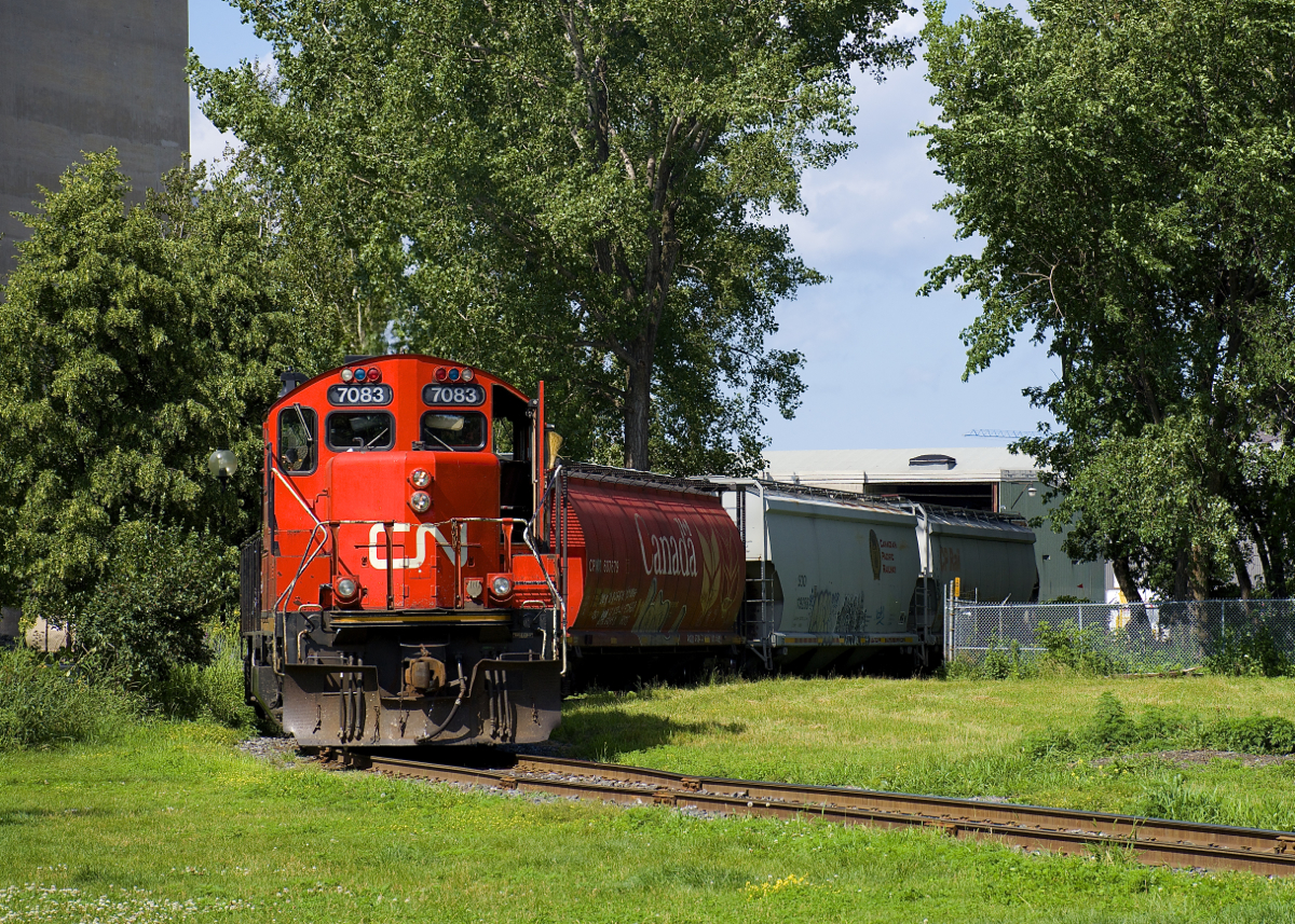 CN 7083 & CN 7054 shove eight cars grain cars into the Robin Hood Flour Mill on CN's East Side Canal Bank Spur, with the tracks curving in front of the train.