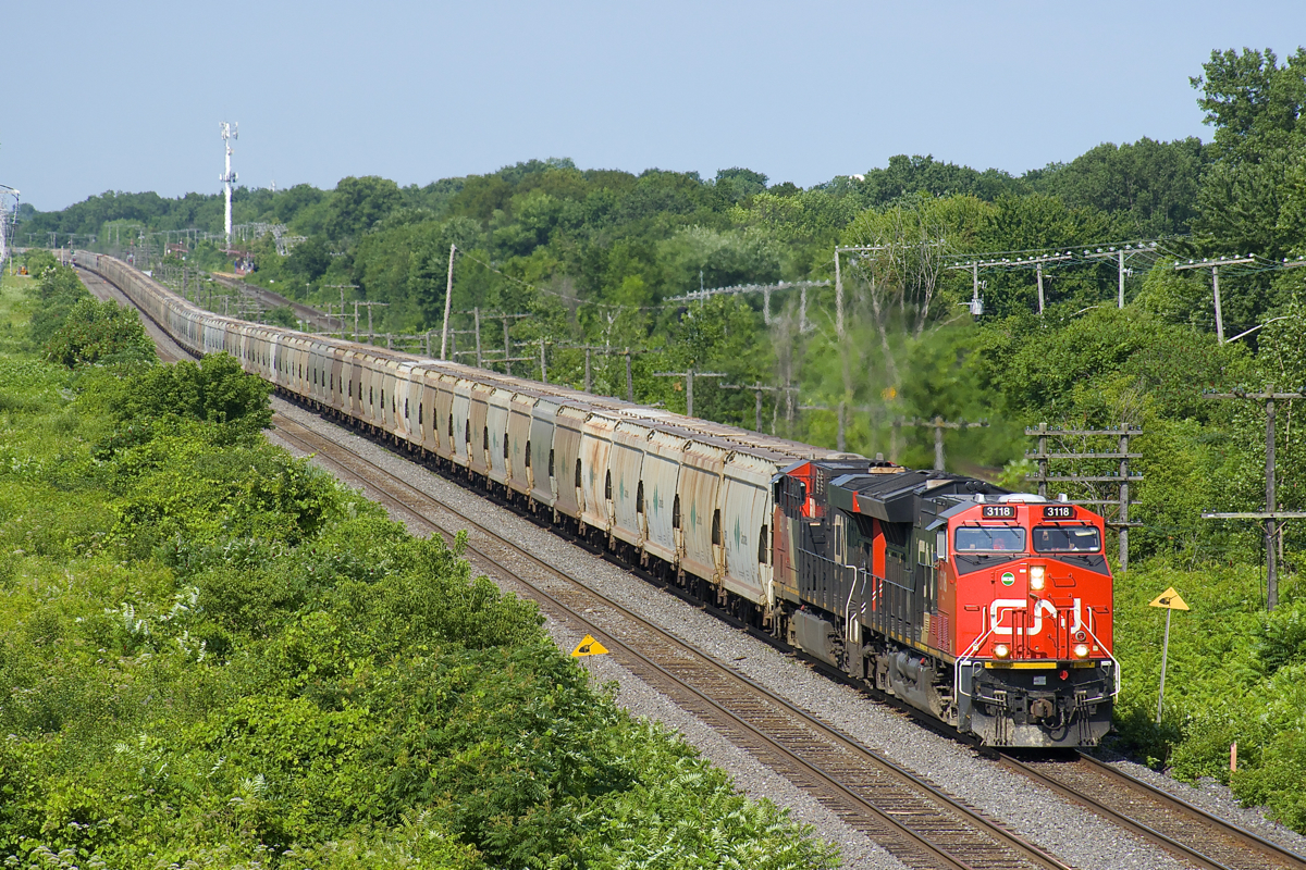 CN B730 has CN 3118 & CN 2964 up front, CN 3041 mid-train and CN 3062 on the tail end as it heads through Beaconsfield with 205 potash loads destined for Saint John, NB.