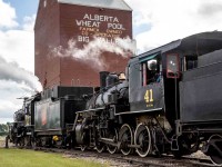 As a celebration of Canada's 150th anniversary as a nation, the Alberta Prairie Railway (APR) joined with the Alberta Railway Museum (AMR) in bringing their two steam locomotives together to run double-headed passenger trains between Stettler and Big Valley, Alberta for a week around Canada Day in 2017.  The locomotives involved are the APR 2-8-0 #41 ex-Mississippi Railway, and ARM 4-6-0 #1392 ex-Canadian National.  These photos show the activity on their many runs between these two centers.  In this image #1392 leads #41 to the water tank car before the restored grain elevator in the terminus town of Big Valley, Alberta.