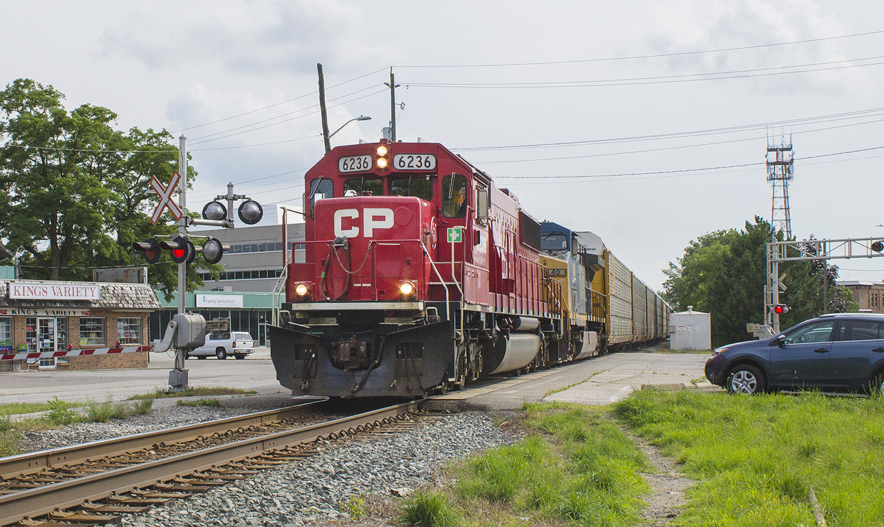 THREE IN ONE!!!  A good tip always helps when trying to photograph trains...especially if you don't own a scanner. It's Friday evening, and I had just gotten off of work. I saw a text on my phone from my wife who works in Tilbury. She let me know there was a train slowly making it's way to Chatham. By this time, 20 minutes had passed between the time my wife sent the text and I received it. I knew the train was coming...


Inspired by a Bruce Mercer photo taken at King & Adelaide Streets downtown Chatham some 30 years prior, I setup shop on the opposite side of the tracks  from where he took his photo. Just in the foreground remains the rails to what was the station lead. The station itself would have been straight ahead of me directly across the intersection. It is now marked by a mature growth of trees. And in rolled the train I had been waiting for...former SOO SD60 6036 (now CP 6236) with CSX 40 haul their auto racks past me. Canadian Pacific owned and yet a former SOO with the CSX as it's second in command. Awesome start to the weekend.