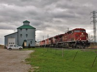 CP 141 with a pair of retired SD40-2F locomotives on their way to meet their maker, passes the old elevator in Elmstead, ON. 
