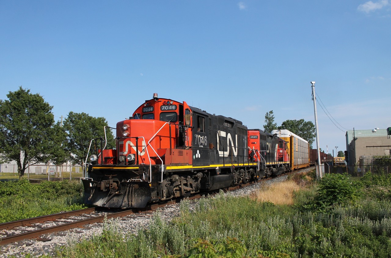 The late afternoon local out of CN Van De Water Yard traverses the CN Pelton Spur with CN 7046 (GP9RM) and CN 7081 (GP9RM). Location is Airport Road in Windsor, ON.