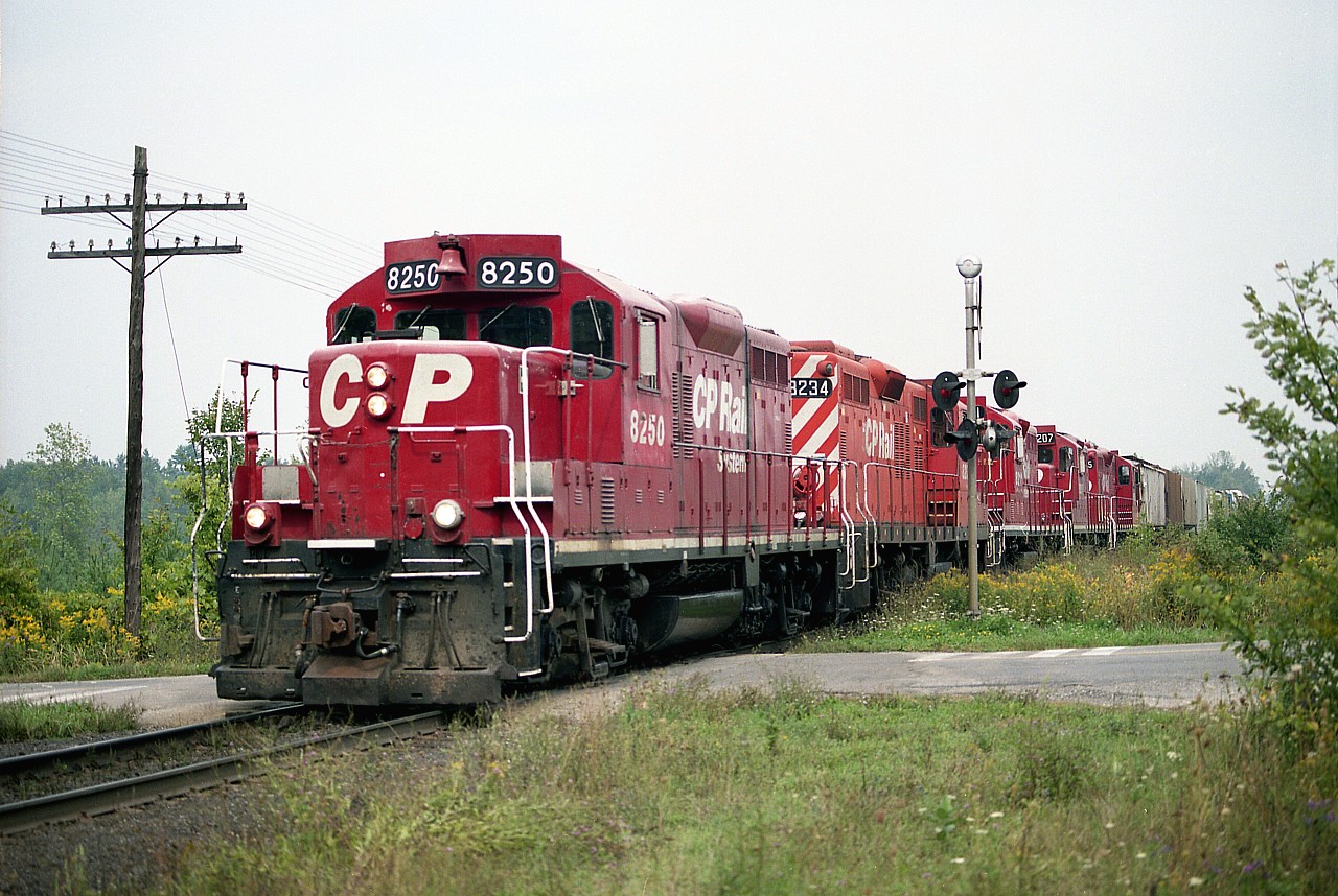 I heard there was a train on the way. I was driving along Campbellville Rd when I heard this guy on the scanner, announcing he was clear of Guelph Jct westbound and the only opportunity was at the clearing opposite the entrance to Mountsberg Conservation Area. But I had no time, as he was really moving, no chance to shoot across the field, resulting in this grab shot at the Milburough Line crossing. I must say I was very surprised. Holy Cow!! Five GP9s!!! CP 8250, 8234, 8211, 8207 and 8215. The GP9u locos are no more on CP; all numbers in this batch retired in 2015.
