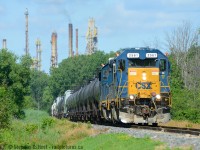 With smokestacks from Sarnia refineries in the background, I'm at Tashmoo Ave near Sarnia, on the Aamjiwnaang First Nation Reserve. The CSX transfer has just left home rails and has entered the St. Clair River spur with 20 or so cars for CN. This job usually runs daily, but for whatever reason on the July 1 weekend they did not run on Saturday July 1 or Sunday July 2. On the 3rd, D724 (Sarnia to Sombra turn) was ordered along with this yard job.