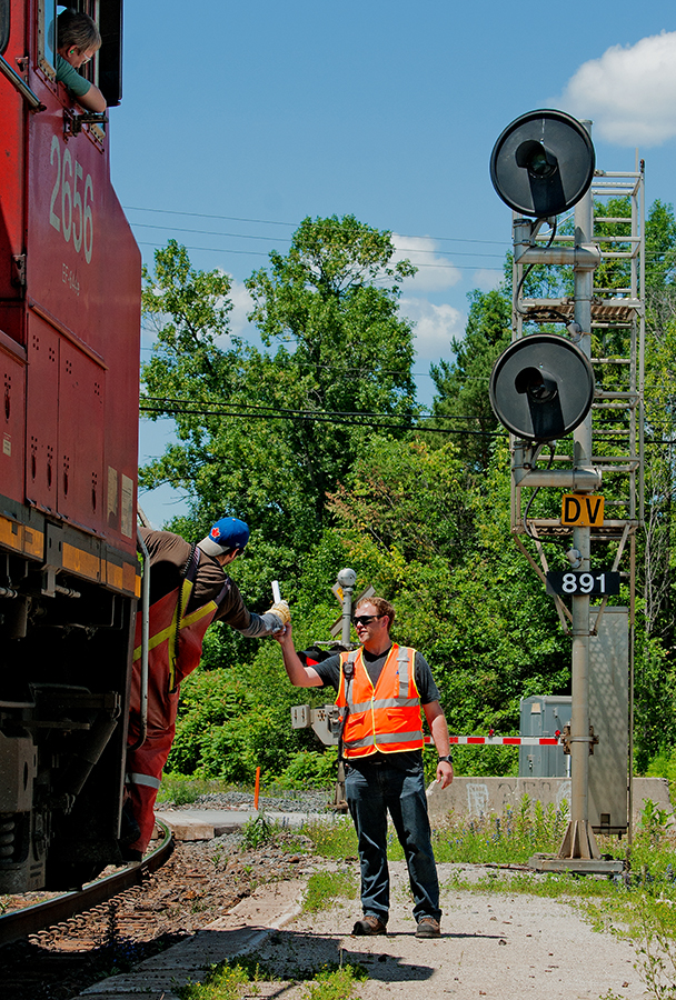 Mr. Robert Eull is seen handing off orders to northbound 105 at Washago as the engineer looks on to the exchange.