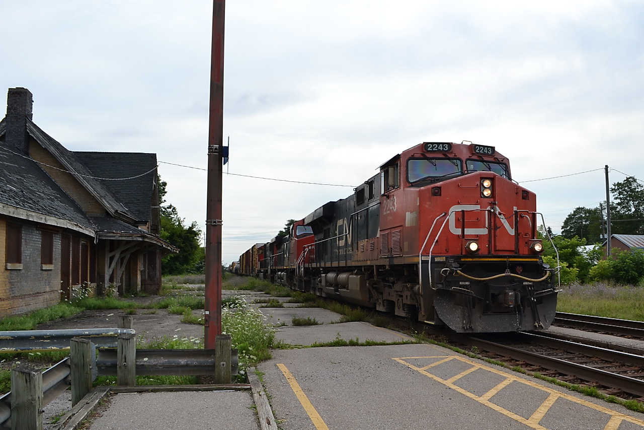 CN train 394 crawls pass the run down old CNR Station in Ingersoll, Ontario. It is sad the disrepair the station has fallen into.