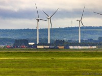 Taken with my 150-600mm lens, from Sackville, New Brunswick, CN 407 is seen rounding the bend at Fort Beausejour, New Brunswick, about 5 miles away, passing the turbines, which, in reality, are actually in Nova Scotia, as the train is crossing over the border. 