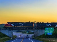 At sunrise, westbound train 473 departs Moncton, New Brunswick, heading for Joffre, PQ. Seen here, at Berry Mills, New Brunswick. 