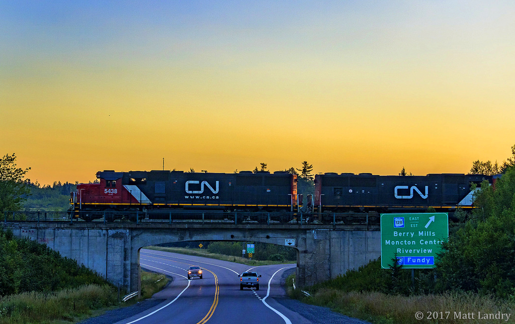 At sunrise, westbound train 473 departs Moncton, New Brunswick, heading for Joffre, PQ. Seen here, at Berry Mills, New Brunswick.