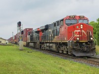 Like many of the smaller communities along the Canadian Nationals Strathroy Subdivision, Watford has not changed much through the years. Having boasted one of the larger stations at one time, it was demolished as the railway did not wish to continue the maintenance of the building. With all passenger traffic being swirched over to VIA Rail, they started to build smaller, less attractive 'stations' along their corridors. Here, we see the Chicago to Toronto container train passing the current CN maintenance office. Of note, is the light standard just to the left of the signals. That remains from one of those small VIA shelter that existed until the early to mid 2000's before it too was demolished, probably due to low ridership. A similar structure still exists to the west in Wyoming.