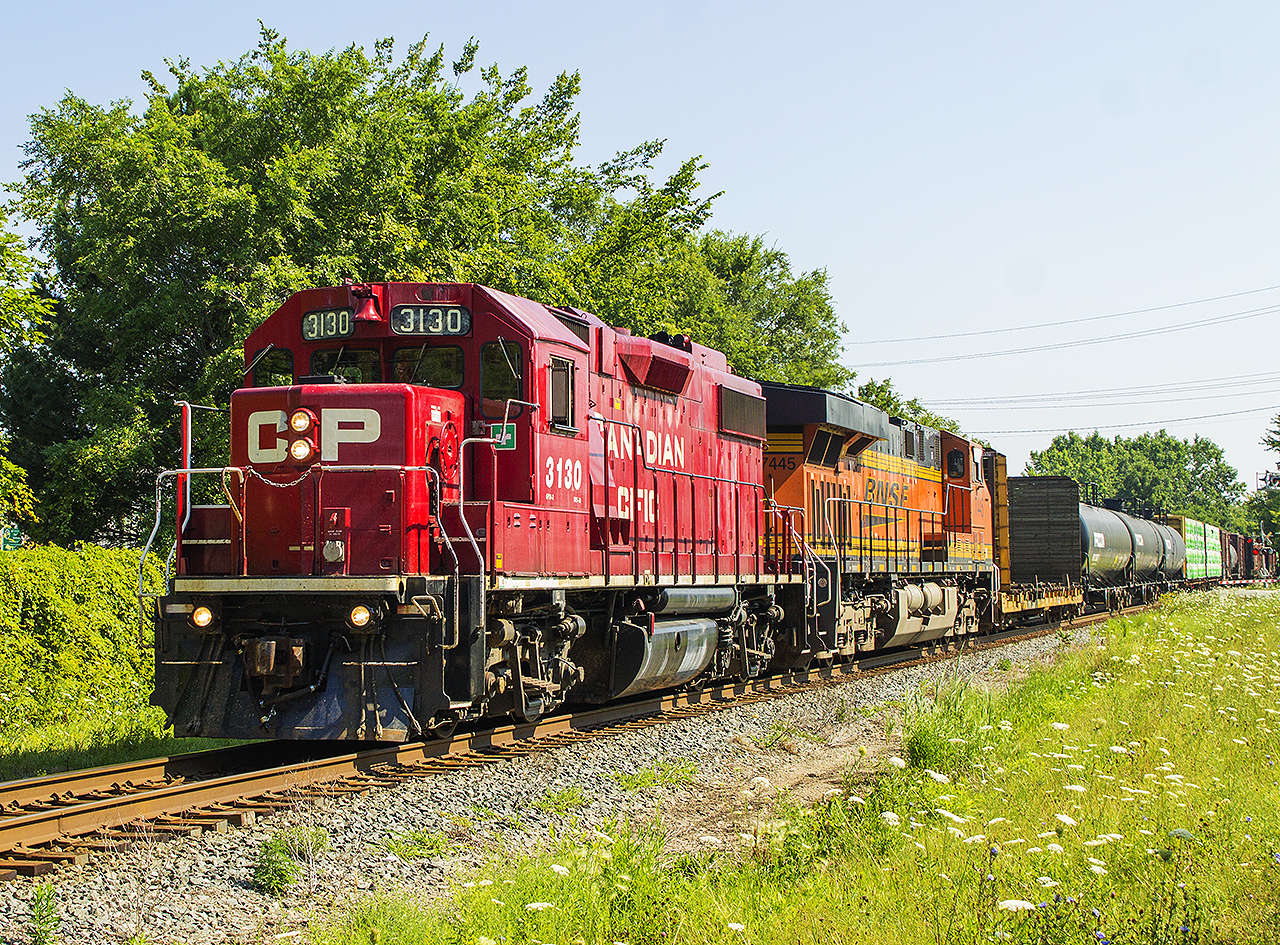 Hard to believe that in behind this train used to stand the CPR station for Chatham. Now a municipal parking lot with overgrown trees and bushes acting as a safety barrier, a nice colourful lashup between the CP and BNSF units lead this westbound through the downtown core.