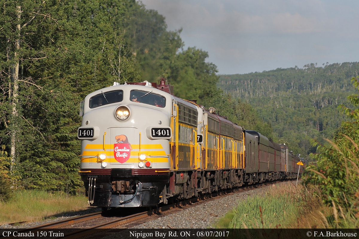 The CP Nipigon sub parallels the Trans Canada Highway in many places, including the intersection with Nipigon Bay Road. The CP Canada 150 train approaches on a rare section of straight track.