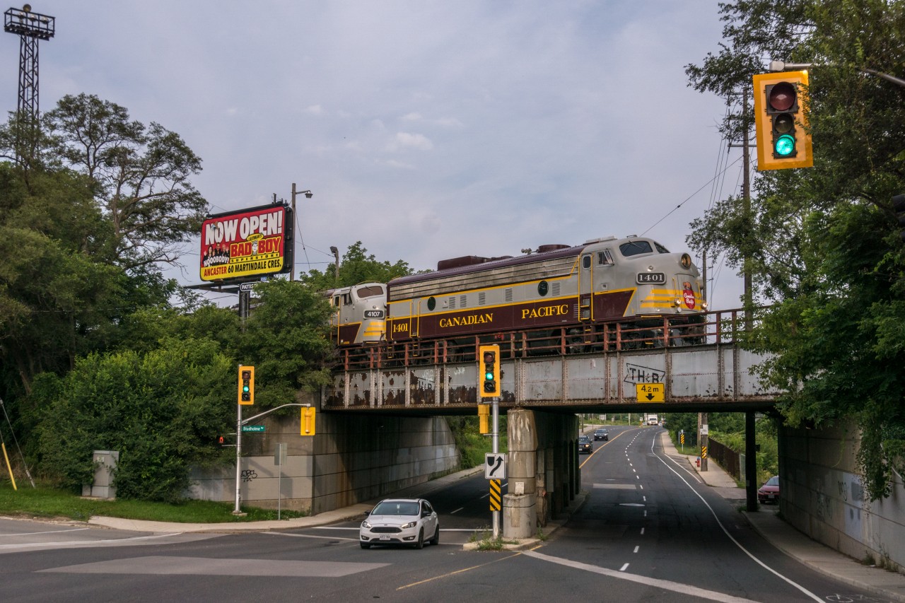 Having spent the night in CP's Aberdeen Yard after the performance the night before at Kinnear Yard, the CP Canada 150 Train gets underway enroute to Toronto Yard. The train would encounter air and mechanical problems which would cost it nearly an hour as it returned to the yard for diagnosis and repair. Anyone who had remained at this location would have thus been afforded with two subsequent retakes at this shot. We had moved on, expecting to have to race ahead, so this was a welcome wrench for those of us trying to maximize photo opportunities. Thankfully for those involved with the train, there was no particular time constraint; the train was simply heading for servicing before the next performance the day after.

A couple of my videos of this train from the previous day: 
 CP Canada 150 Train at Baxter 
 CP Canada 150 Train south of Guelph Junction
