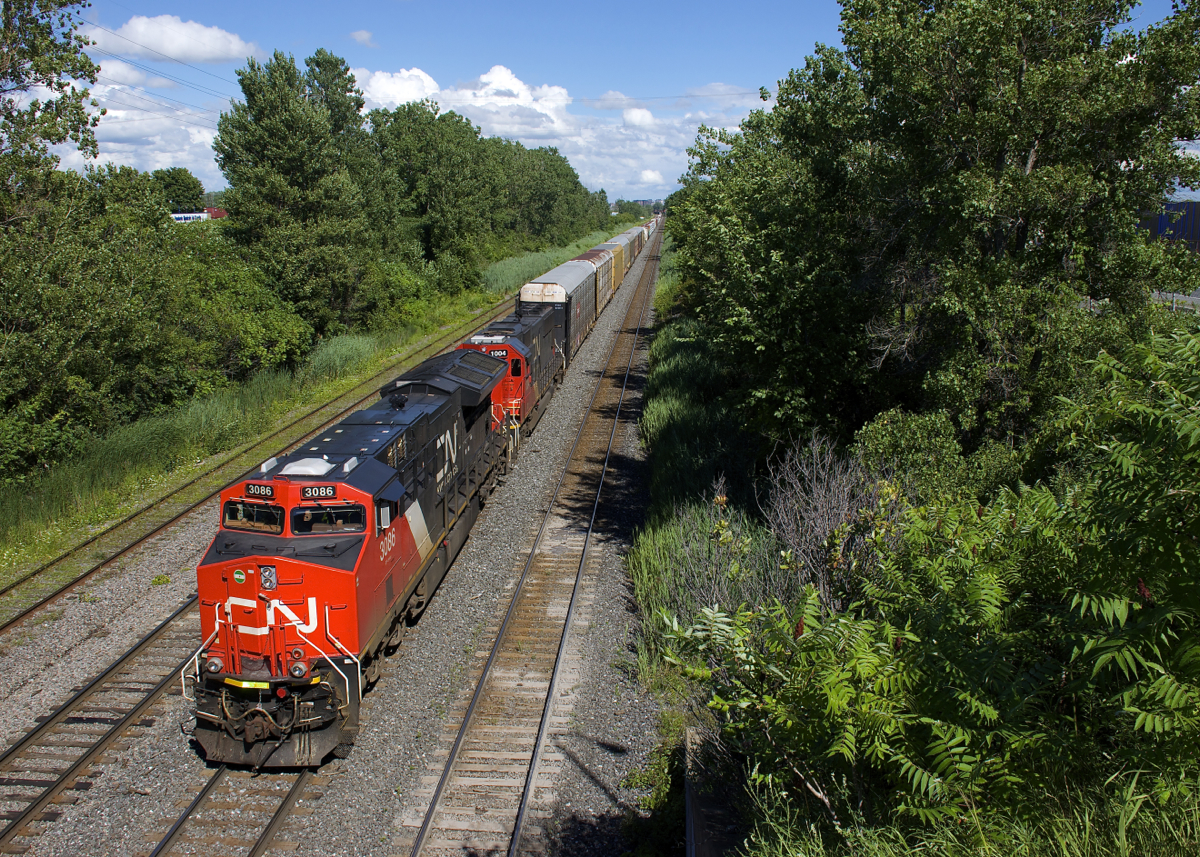CN 3086 & IC 1004 lead CN 401 through Lachine, the terminus of Taschereau Yard nearly in sight.